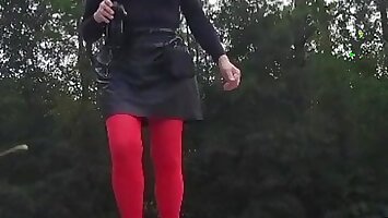 Crossdresser outdoors quick walk in leather skirt.